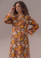 Seated model wearing Retro Rust 2 piece printed lawn co-ord set by Mirasl with abstract printed shirt, wide trouser, and summer ready styling.