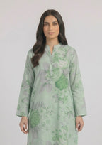 Seated model wearing Mint Meadow 2 piece printed lawn co-ord set by Mirasl with knee-level floral shirt, printed trouser, and summer ready styling.