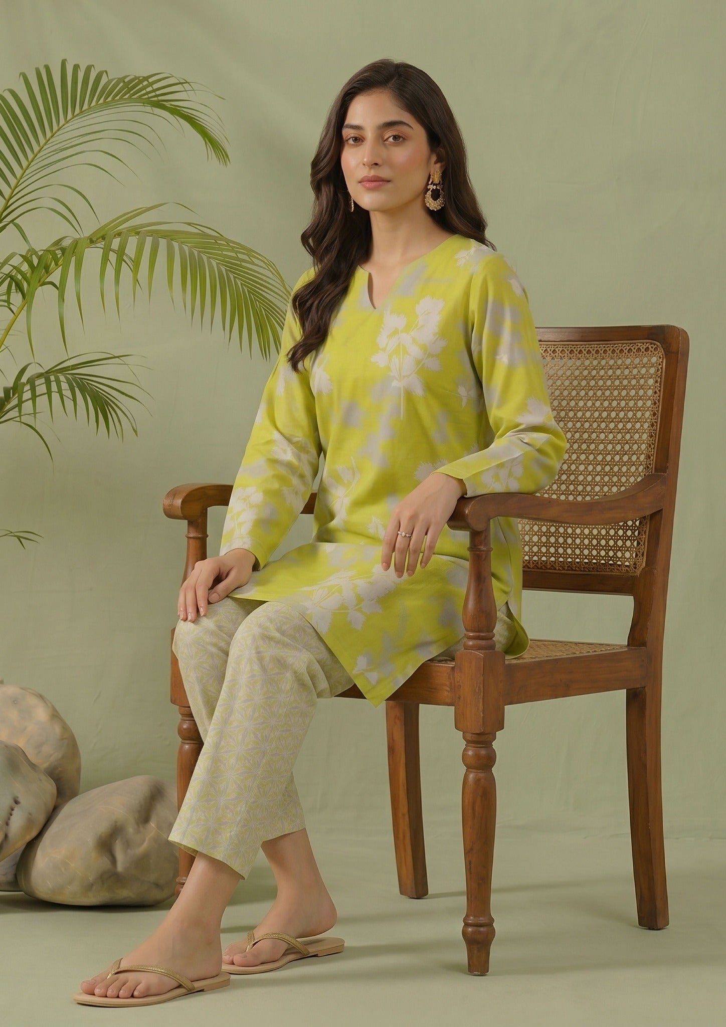 Seated model wearing Lime Lattice printed lawn co-ord set by Mirasl with lime green floral shirt, white lattice trouser, and summer ready styling.