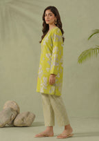 Walking view of Lime Lattice by Mirasl featuring a lime green printed lawn shirt with soft white floral details and matching lattice trouser.