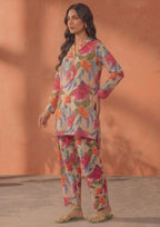 Seated model wearing Ivory Blossom 2 piece printed lawn co-ord set by Mirasl with knee-level floral shirt, matching trouser, and summer ready styling.