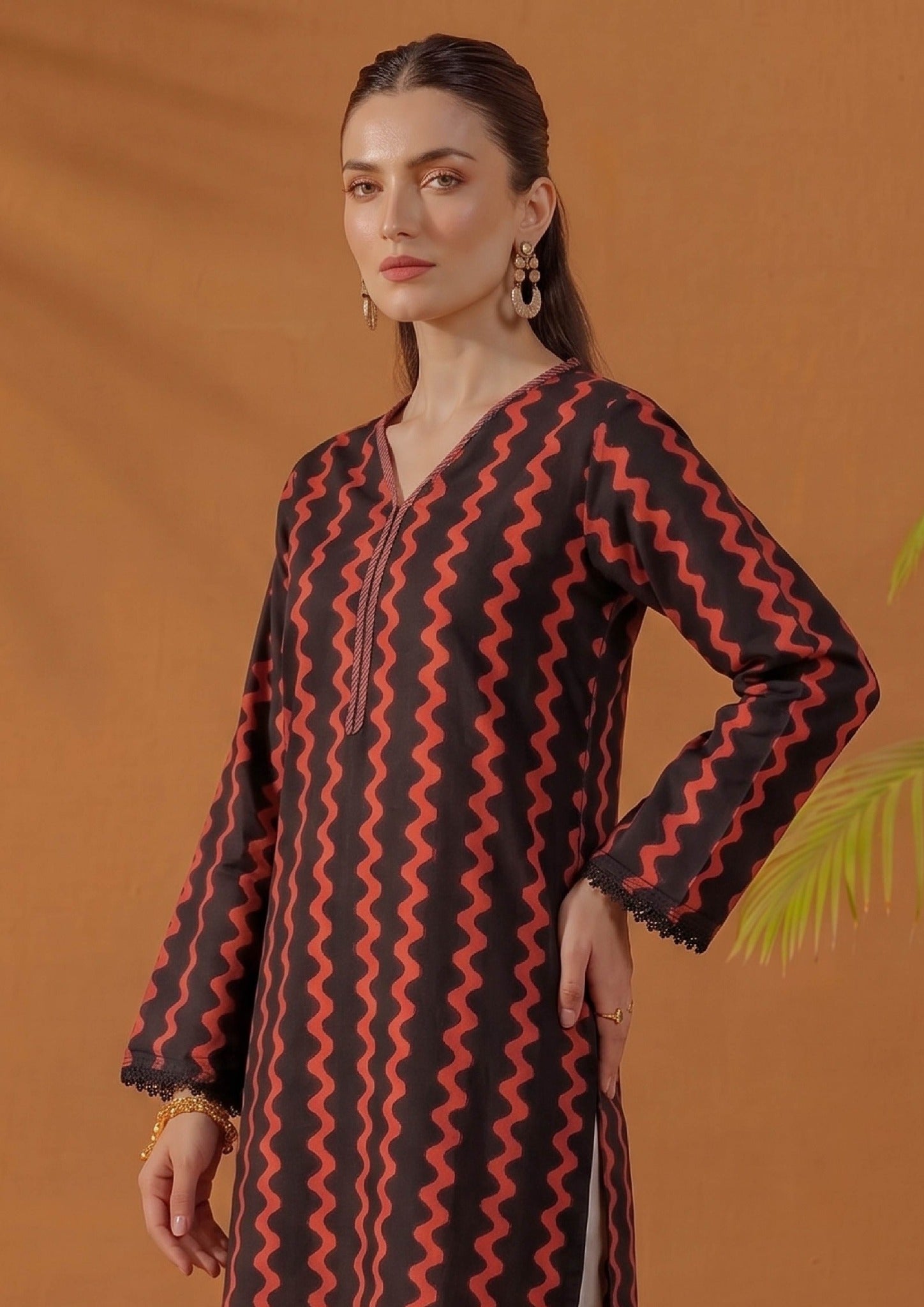 Close-up view of Crimson Ripple by Mirasl featuring black printed lawn fabric with crimson red wave motifs, V-neckline, front placket detail, and lace sleeve finishing.