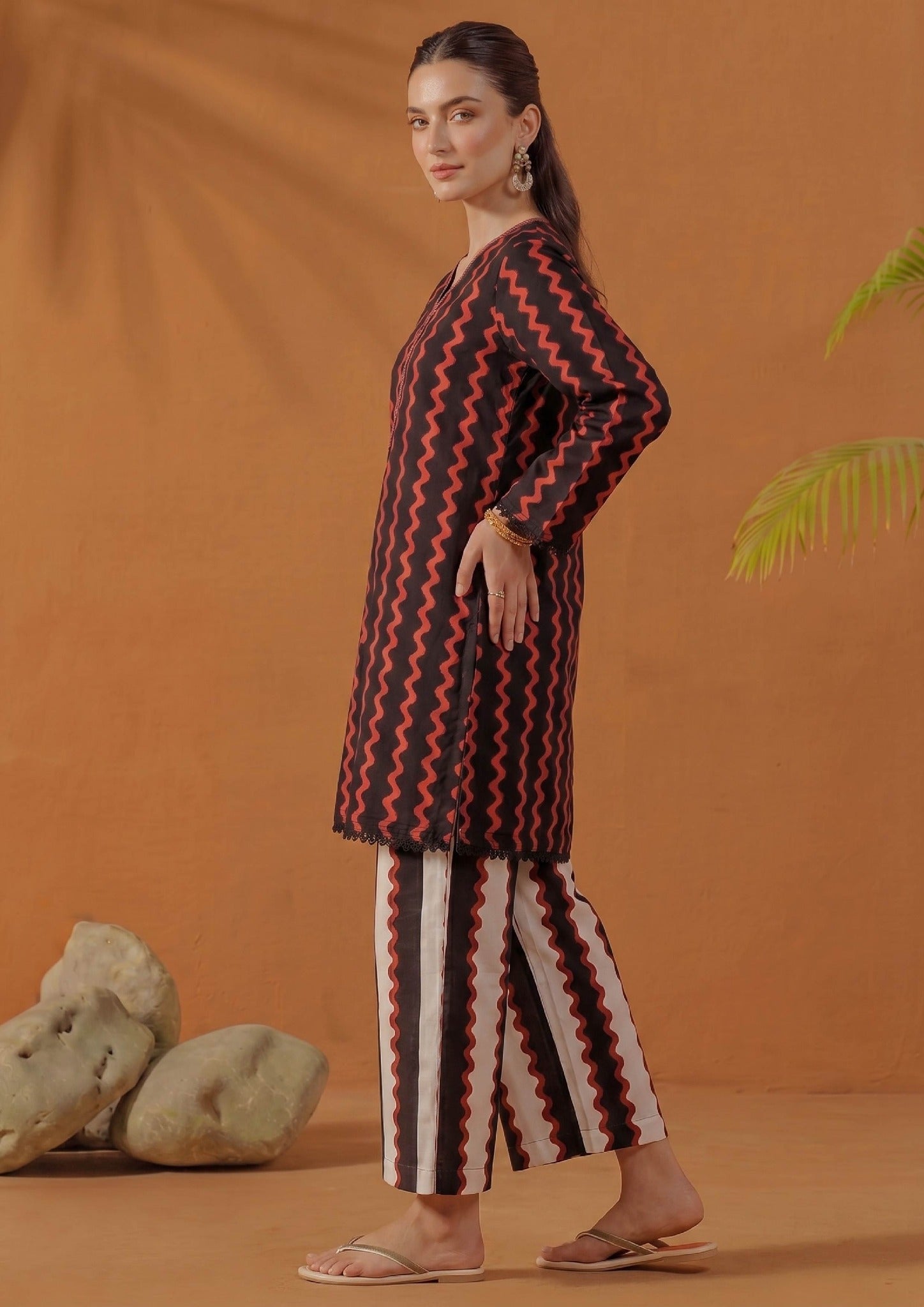 Side view of Crimson Ripple printed lawn co-ord set showing the relaxed straight fit, knee-level shirt, full sleeves, black and red ripple print, and striped printed trouser.