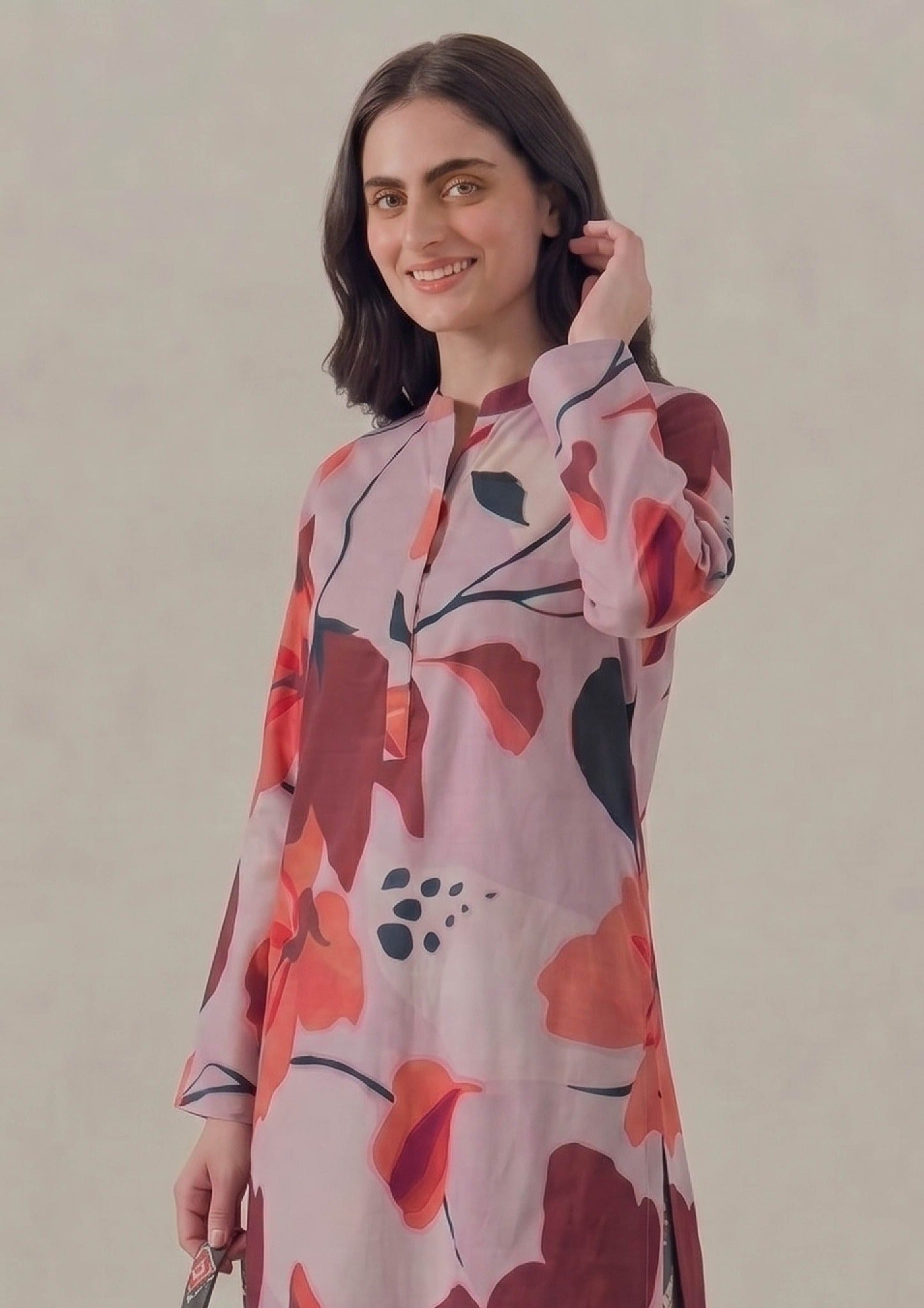 Back side view of Crimson Ikat by Mirasl highlighting the lilac pink floral printed lawn shirt, full sleeves, side slit, charcoal ikat printed trouser, and relaxed modest silhouette.