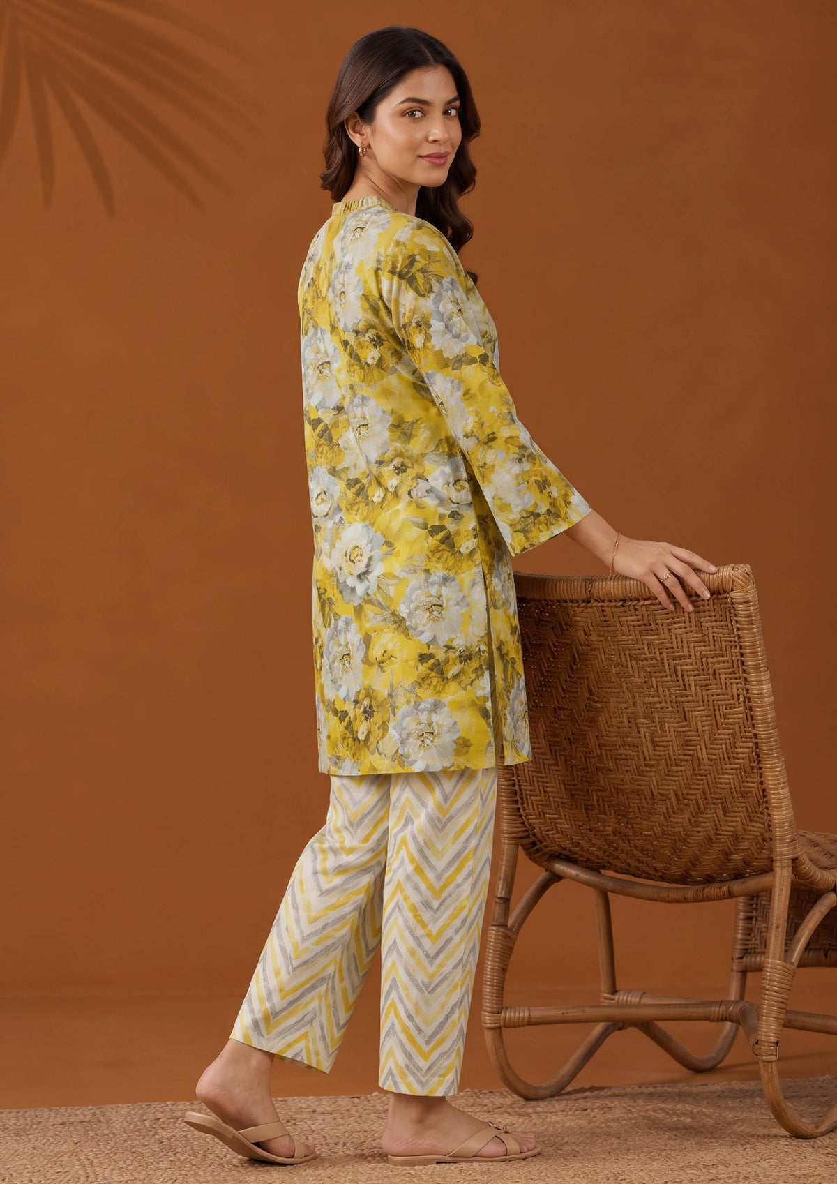 Back side view of Solenne printed lawn suit showing mustard floral shirt and coordinated yellow chevron trousers by Mirasl