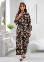 Front walking view of Abstract Petal Noir black 2 piece coard suit with sandy beige floral print kurta and matching wide-leg trouser