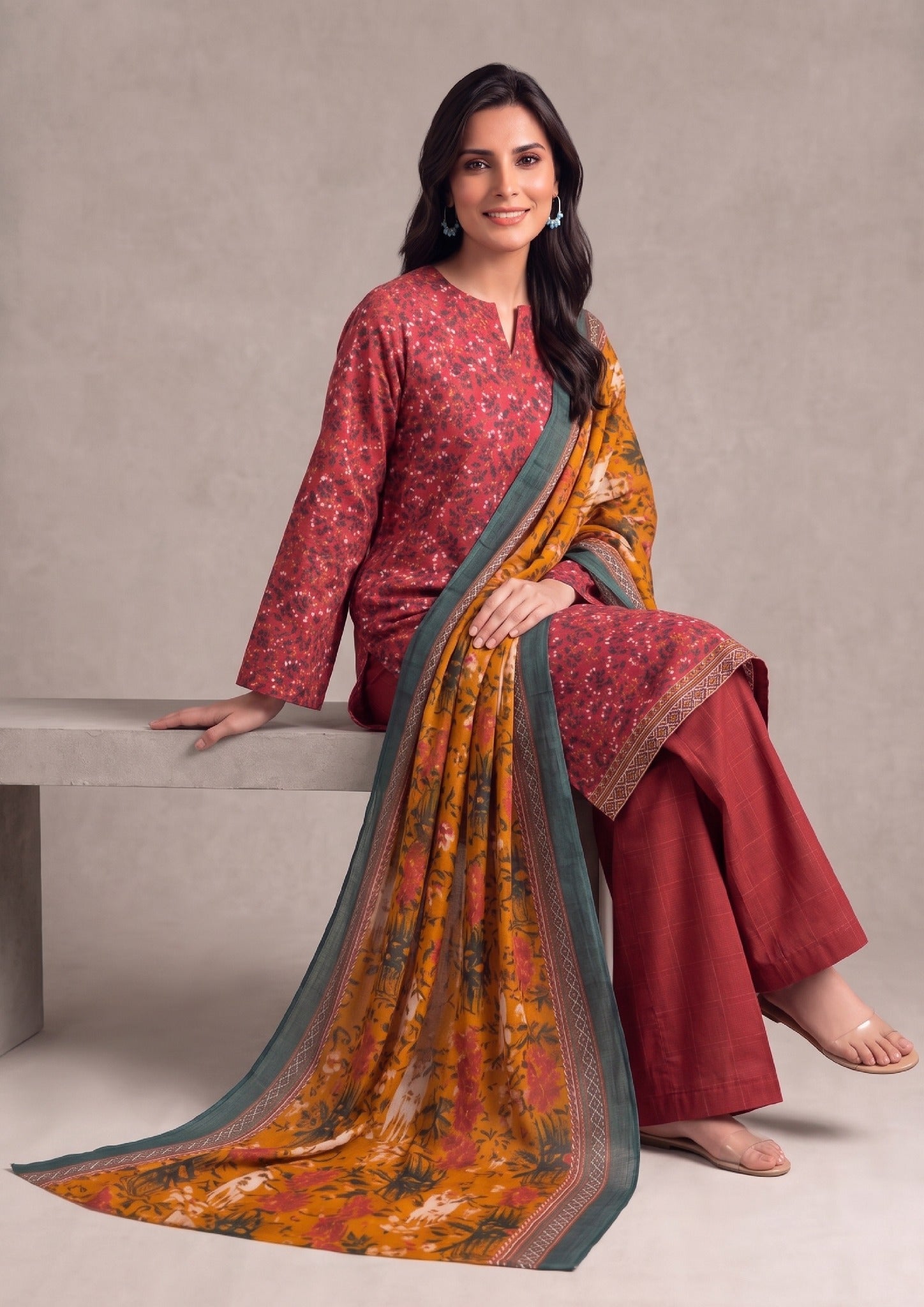 Seated view of Amber Glow ready-to-wear Printed Lawn Suit for women with coordinated amber dupatta and red trouser