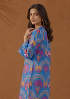 Model wearing Mirasl Azure Oasis 2 piece co-ord set with azure blue printed lawn knee-level shirt and white straight trouser.