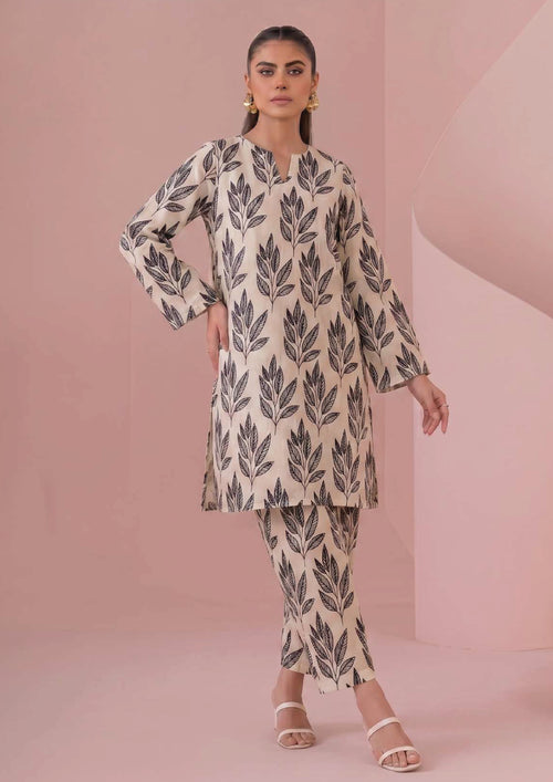 Seated view of Botanical Foliage Noir 2 Piece Coard Suit by Mirasl in ivory lawn with black foliage print and straight trousers