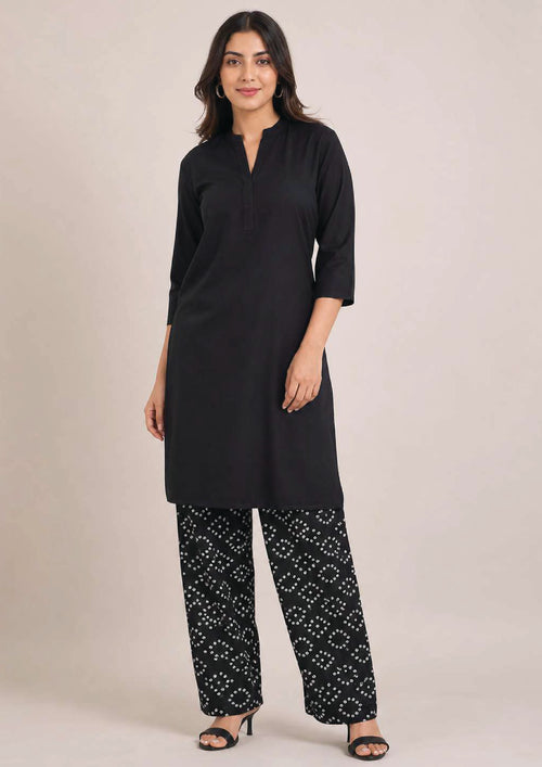 Front view of Chunri Lounge Noir black 2 piece coard suit with solid quarter sleeve shirt and wide-leg white chunri printed trouser