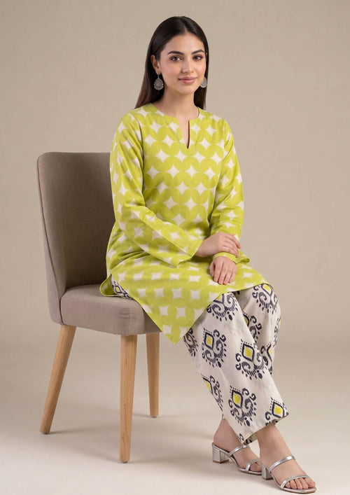 Model wearing Mirasl Citrus Chevron 2 piece co-ord set with citrus lime printed lawn knee-level shirt and contrasting printed straight trouser.