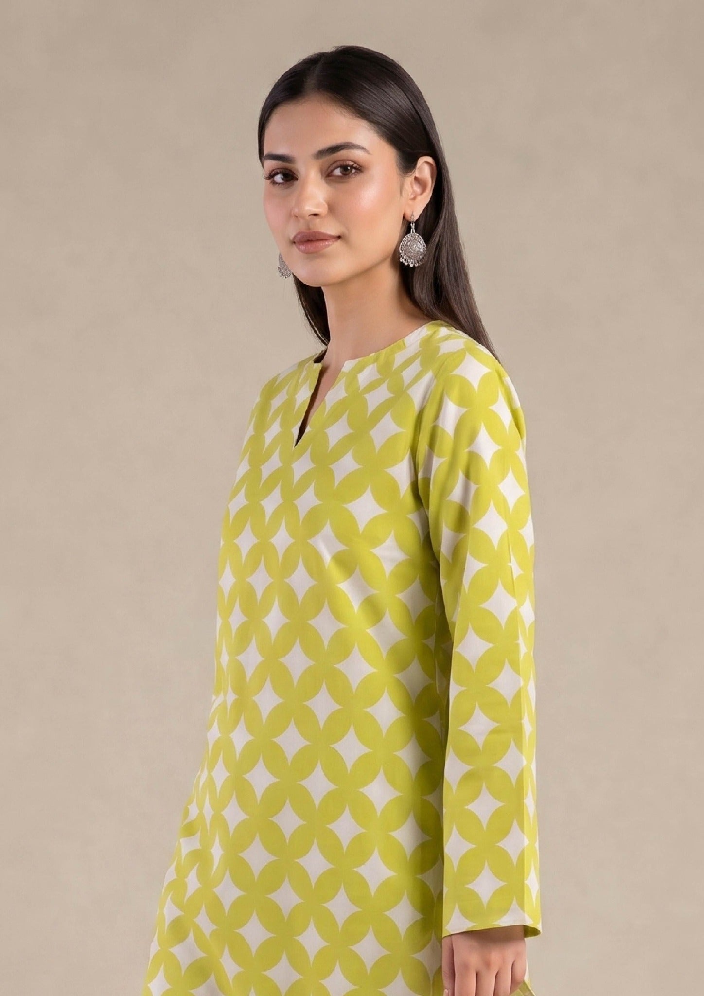 Seated model wearing Mirasl Citrus Chevron ready to wear lawn 2 piece co-ord set with printed straight trouser.