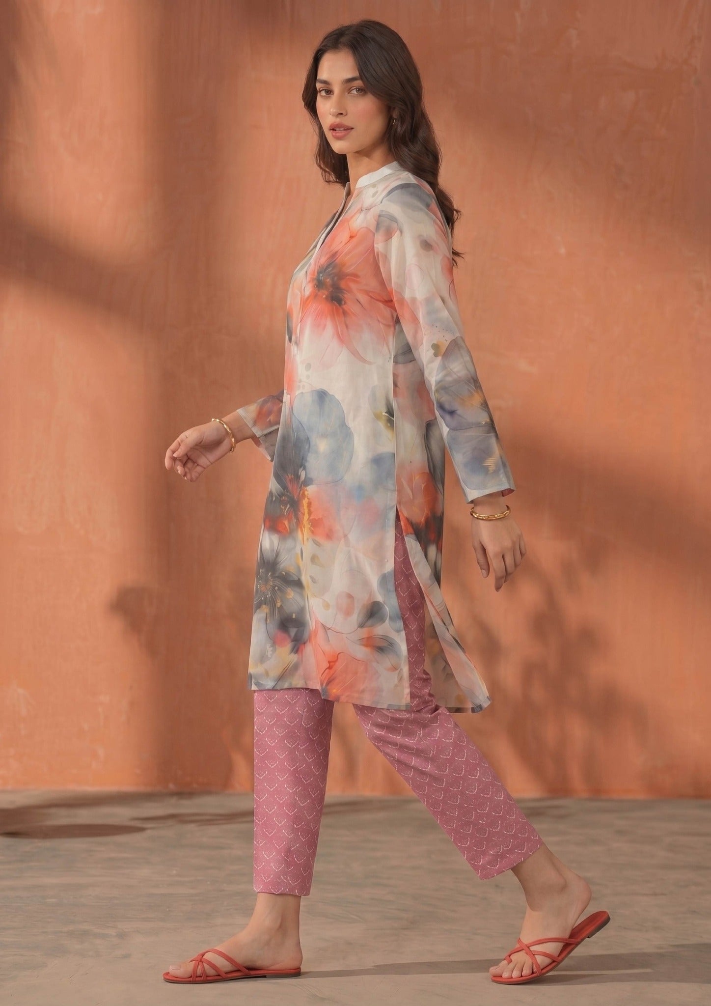 Walking view of Mirasl Coral Dream ready-to-wear printed lawn co-ord set with soft coral floral shirt and fuchsia trouser.
