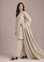 Elegant side pose of Desert Sands printed lawn suit featuring the desert beige printed shirt, coordinated trouser and floral printed dupatta by Mirasl.