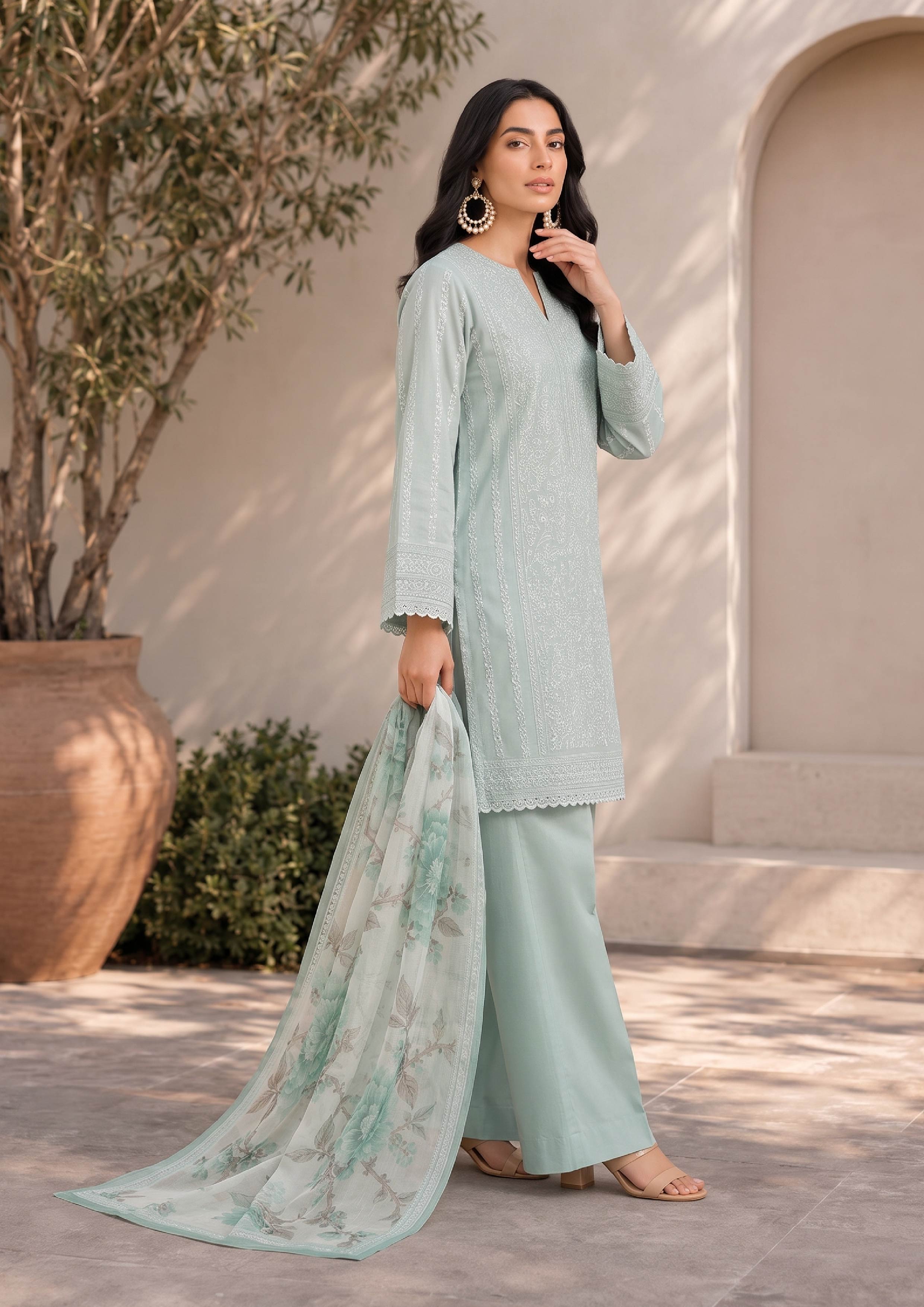 Sophisticated side standing pose featuring a mint green embroidered lawn suit with a white floral printed dupatta and mint green palazzo trousers for contemporary Pakistani women's fashion – fasl-e-rang – mirasl