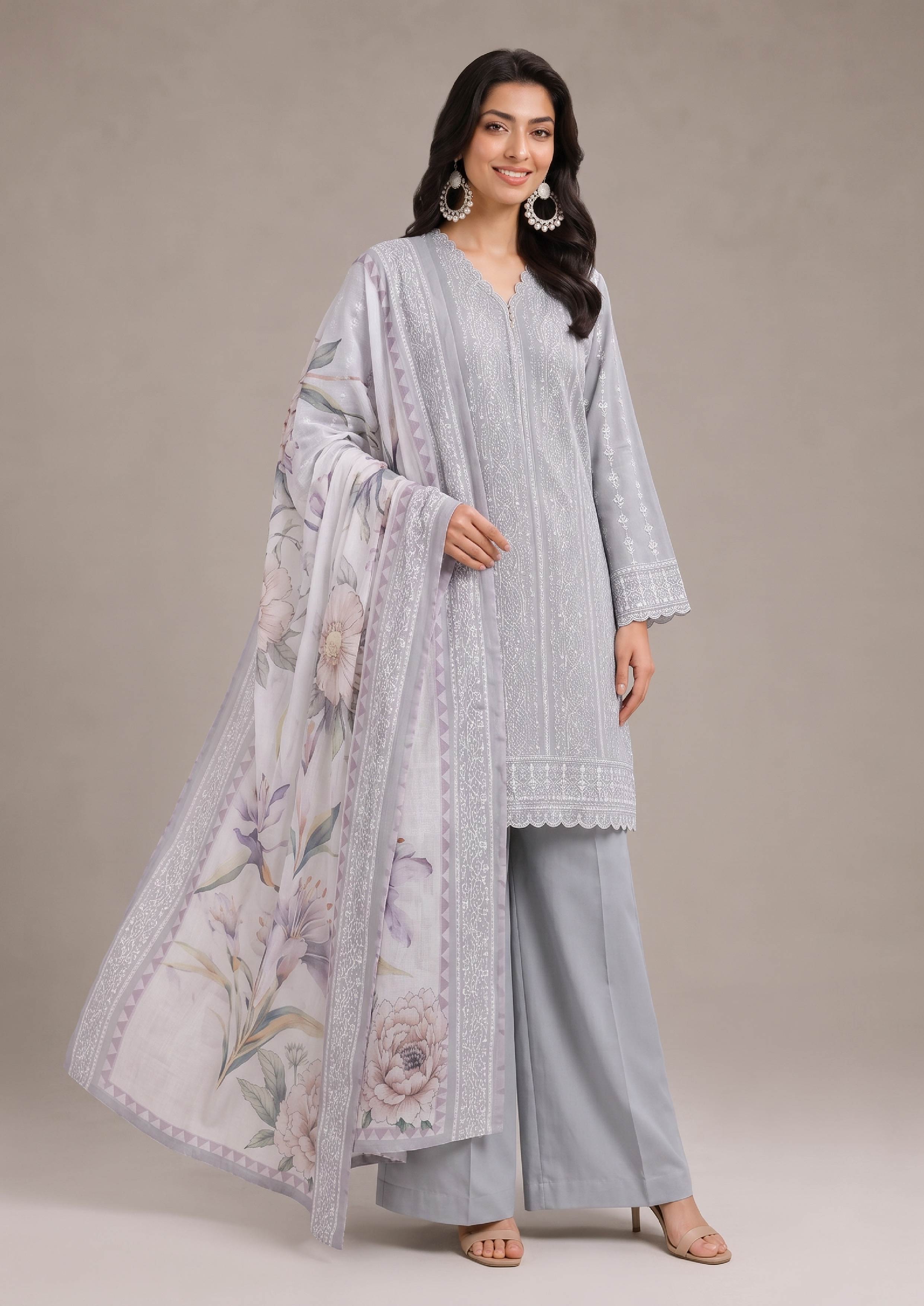 Beautiful embroidered lawn suit in pearl grey with mist grey trousers and a soft lilac floral dupatta, smiling front view highlighting premium Pakistani women's fashion from the fasl-e-rang collection by mirasl.