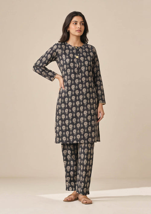 Full front view of Floral Co-ord Noir black floral coard suit with round neckline, button placket and matching printed trouser