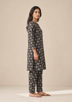 Seated view of Floral Co-ord Noir printed lawn coard suit with coordinated floral shirt and straight-leg trouser