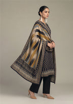Seated model wearing Ikat Fusion Noir women stitched lawn suit with artistic ikat dupatta, navy printed kurta and black trouser