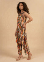 Standing view of Linear Illusion by Mirasl featuring an earthy printed lawn outfit with orange, rust, olive, coral, and dark green linear motifs.
