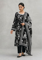 Seated model wearing Midnight Bloom 3 piece stitched lawn suit with statement black and white dupatta