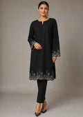 Seated view of Minimalist Noir black 2 piece coard suit with embroidered scalloped hem, sleeve border and tailored trouser