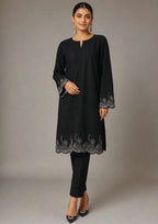 Seated view of Minimalist Noir black 2 piece coard suit with embroidered scalloped hem, sleeve border and tailored trouser