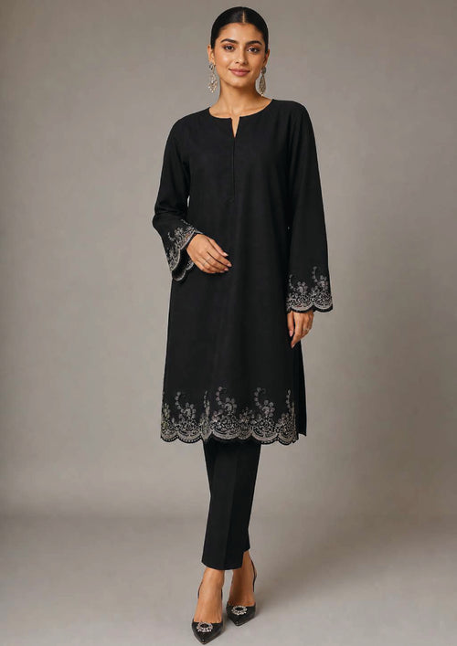 Seated view of Minimalist Noir black 2 piece coard suit with embroidered scalloped hem, sleeve border and tailored trouser