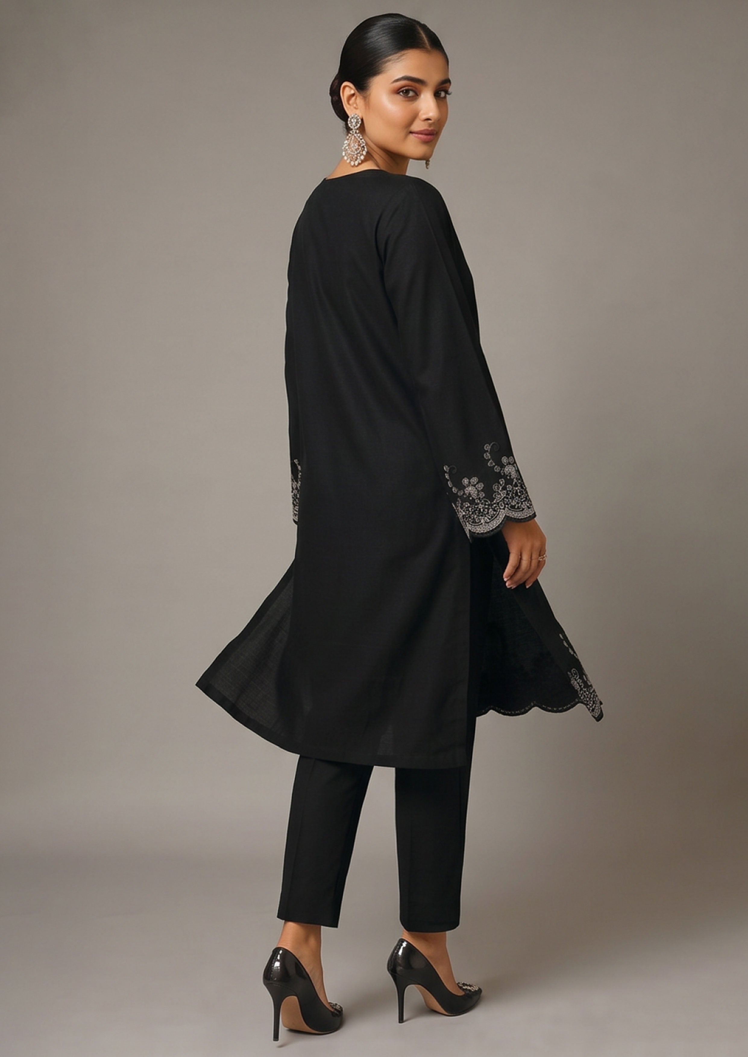 Front view of Minimalist Noir black coard suit for women with long embroidered shirt, scalloped hem and slim black trouser