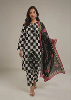 Seated model wearing Mod-Check Noir Pakistani lawn suit with black and white checkered shirt, matching trouser and neon bordered dupatta