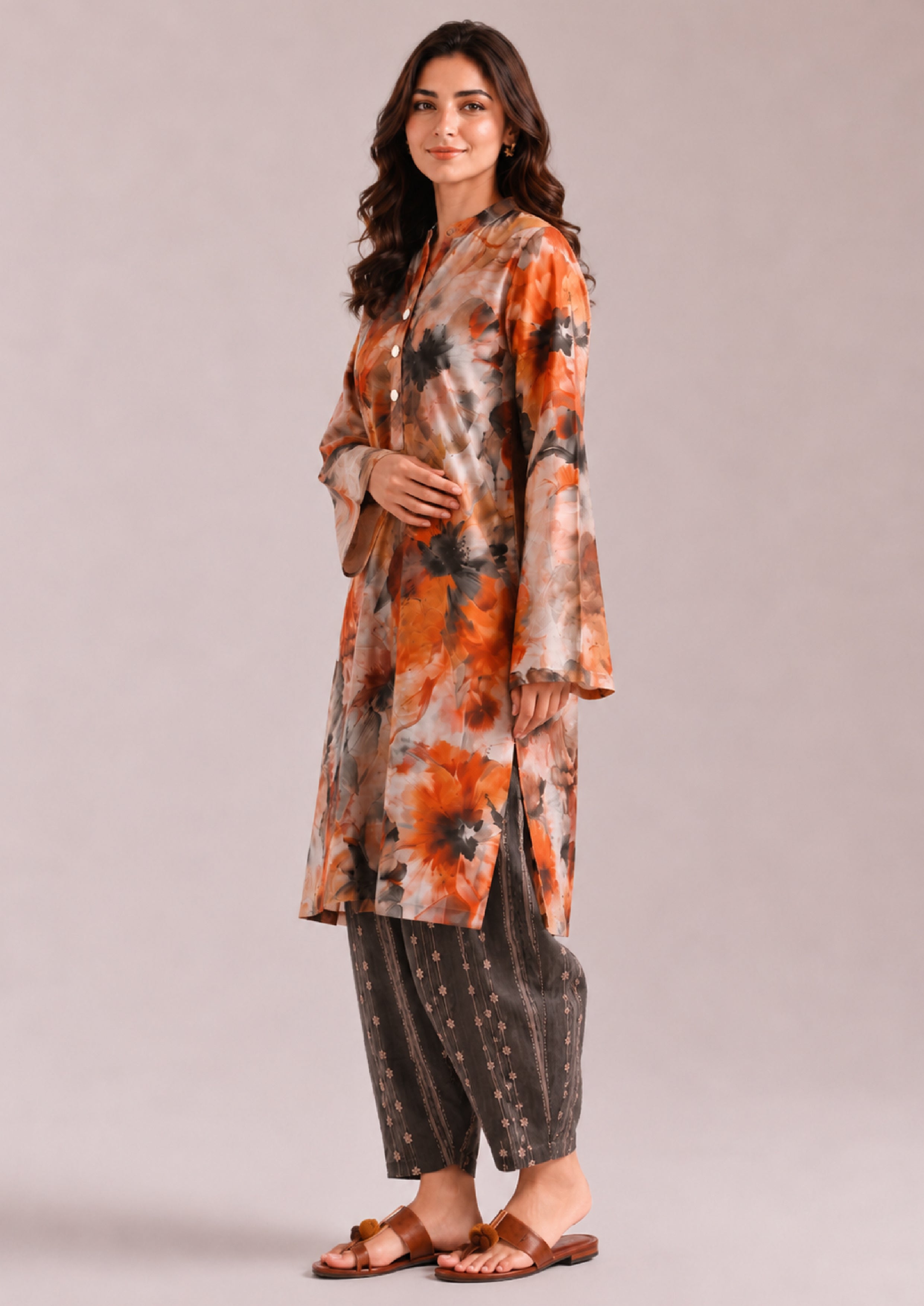 Side view of a women's Printed Lawn Suit featuring an orange, beige and charcoal grey floral printed straight shirt with striped grey trousers from the Fasl-e-Rang collection by Mirasl.