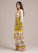 Seated view of Mirasl Palm Grove ready-to-wear printed lawn co-ord set with ivory mustard floral shirt and printed trouser.