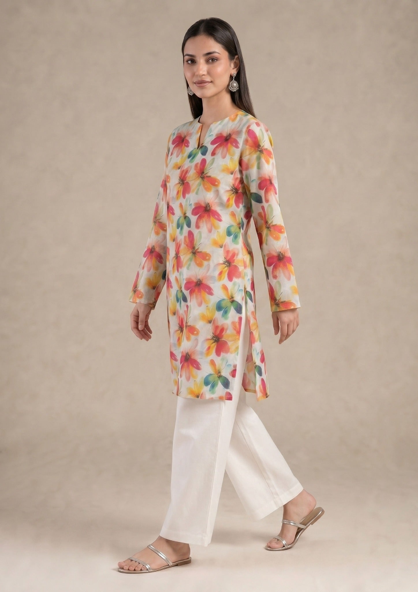 Seated model wearing Petal Radiance 2 piece printed lawn co-ord set by Mirasl with floral printed knee-level shirt and white trouser.