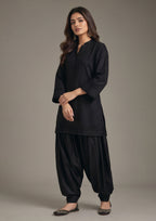 Side angle of Pleated Afghani Noir women co-ord set showing pleated sleeve border, long black shirt and voluminous Afghani trouser
