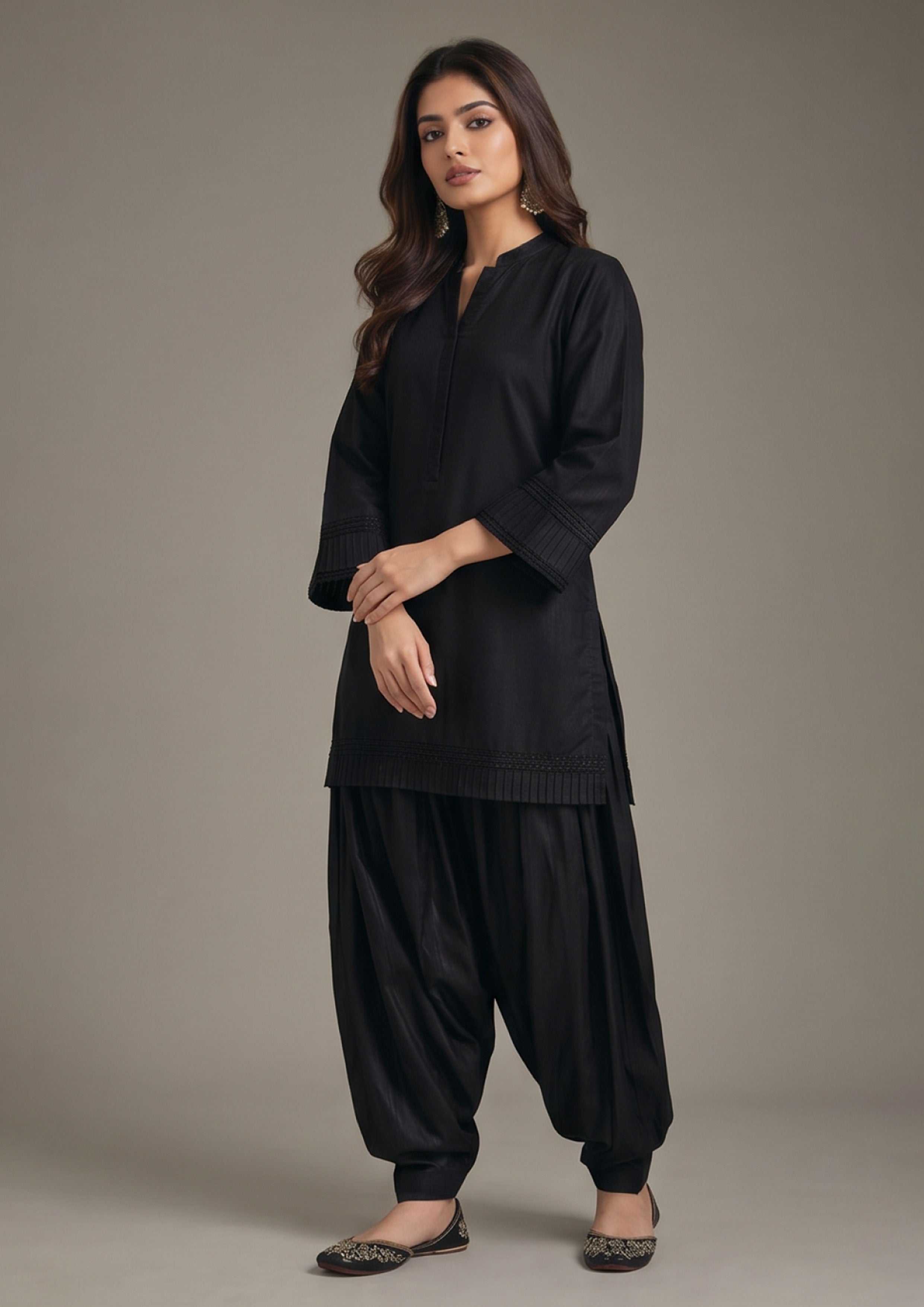 Side angle of Pleated Afghani Noir women co-ord set showing pleated sleeve border, long black shirt and voluminous Afghani trouser